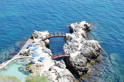 High angle view of footbridges by rock formation over sea