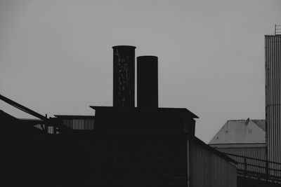 Low angle view of silhouette buildings against clear sky