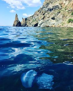 Rocks in sea against blue sky