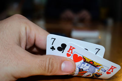 Cropped hand of man holding playing cards