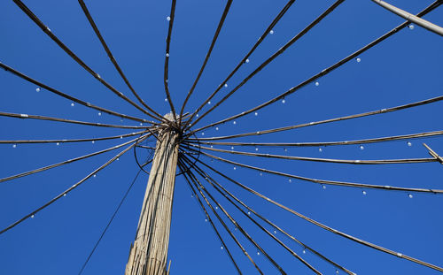 Low angle view of ferris wheel against clear blue sky