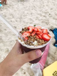 Cropped hand holding food at beach