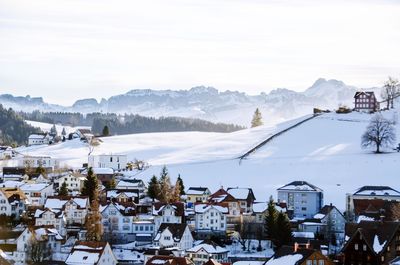 Houses in town against sky during winter