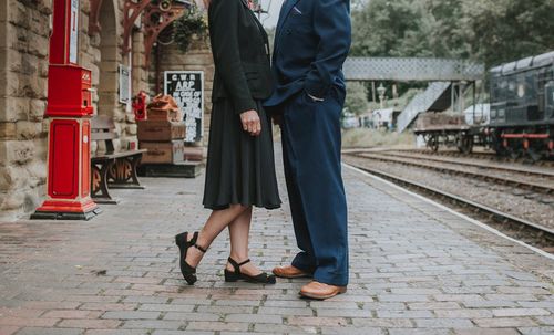 Low section of woman standing on railroad track