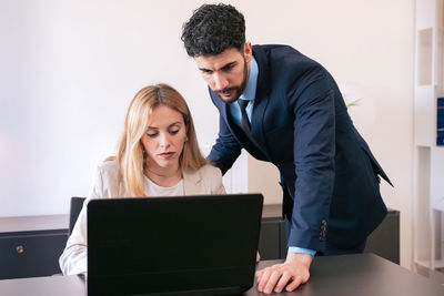Side view of man using laptop at office