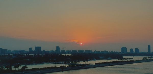 Buildings in city against sky during sunset