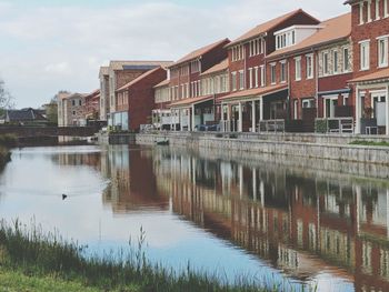 Reflection of buildings in lake against sky