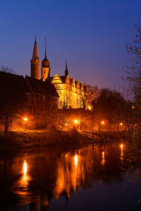 Illuminated buildings against sky at night