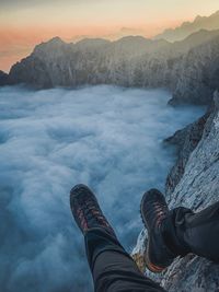 Low section of man on snowcapped mountains during winter
