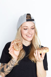 Portrait of smiling young woman wearing hat against white background