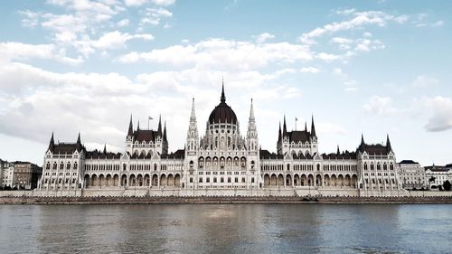 View of parlament building against cloudy sky in city