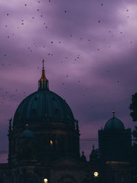 Berlin cathedral against birds flying in sky