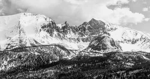 Snow covered rocky landscape against the sky