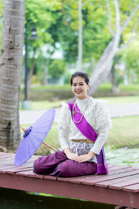 Portrait of a smiling young woman sitting outdoors