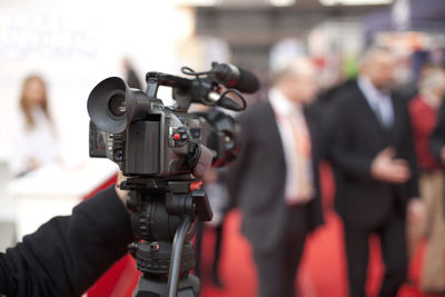 Man filming businessmen through video camera at event