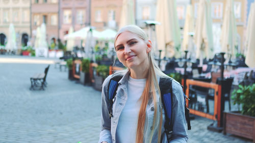 Smiling young woman standing in city