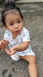 Portrait of cute girl sitting outdoors