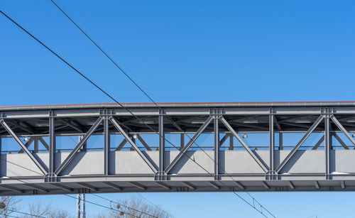 Low angle view of bridge against clear blue sky