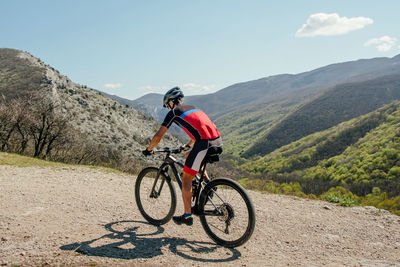 Athlete cyclist riding mountain bike on mountain trail