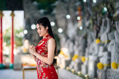 Woman looking away while standing outdoors