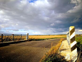 Road by landscape against sky