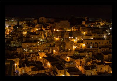 Illuminated cityscape against sky at night