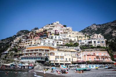 People enjoying at beach against clear sky at amalfi coast