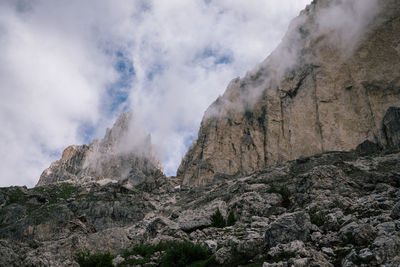 Low angle view of rocky mountains against sky