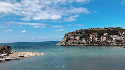 Scenic view of sea by buildings against sky