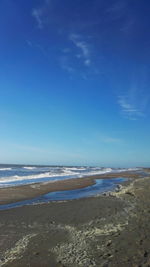 Scenic view of beach against blue sky