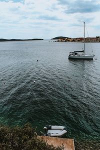 Sailboat moored on sea against sky