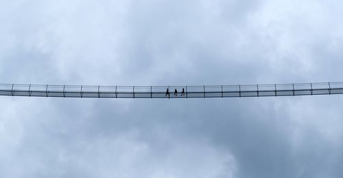 Low angle view of crane against sky