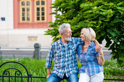 Smiling senior couple sitting on fence