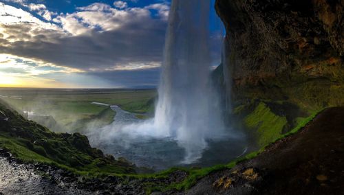 Scenic view of waterfall against sky