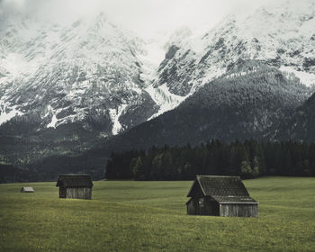 Scenic view of snow covered field by trees and mountains