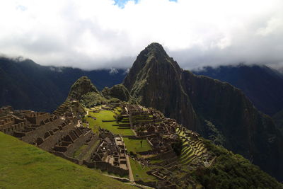 Castle on mountain against cloudy sky