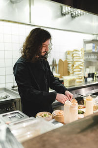 Midsection of woman standing in kitchen