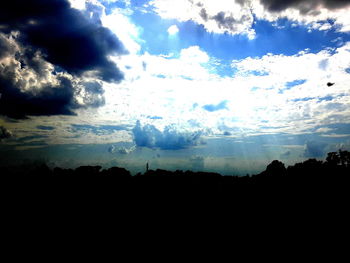 Low angle view of silhouette landscape against dramatic sky