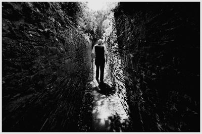 Rear view of man walking in tunnel