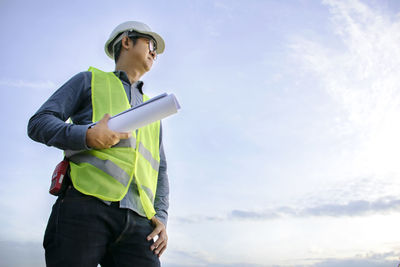 Low angle view of man looking away against sky