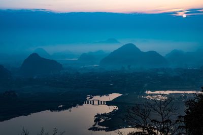 High angle view of calm lake during sunrise in town