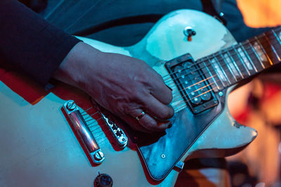 Midsection of man playing guitar