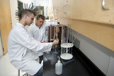 Side view of scientists doing experiment in laboratory 