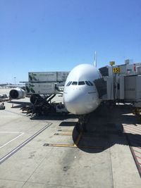 Airplane on airport runway against clear blue sky