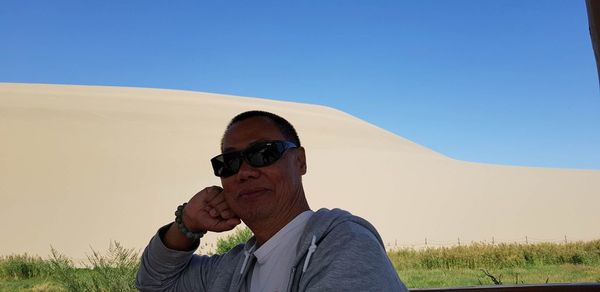 Portrait of man wearing sunglasses against clear sky