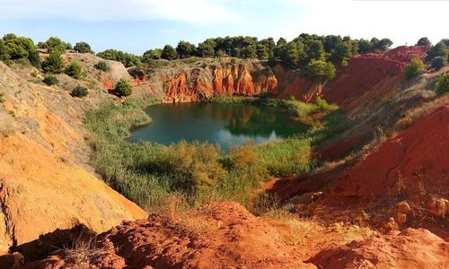 Scenic view of rocks and trees against sky