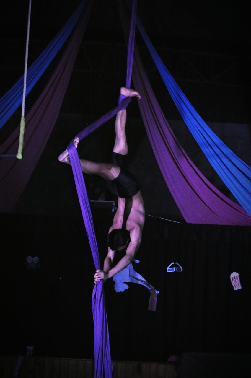 performance, skill, acrobat, real people, lifestyles, arts culture and entertainment, balance, leisure activity, circus, dancing, gymnastics, full length, stage - performance space, upside down, performing arts event, indoors, flexibility, night, acrobatic activity, one person, stunt, stage costume, men, people