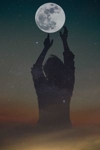 Digital composite image of man holding moon at night