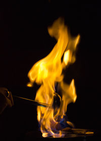 Person cooking food against black background