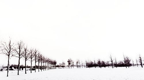 Snow covered field against clear sky